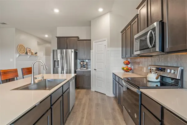 a kitchen with stainless steel appliances granite countertop a sink stove and refrigerator
