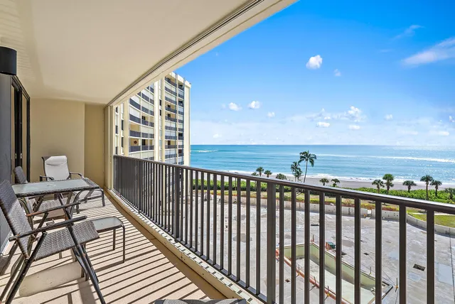 a view of a balcony with wooden floor and outdoor seating