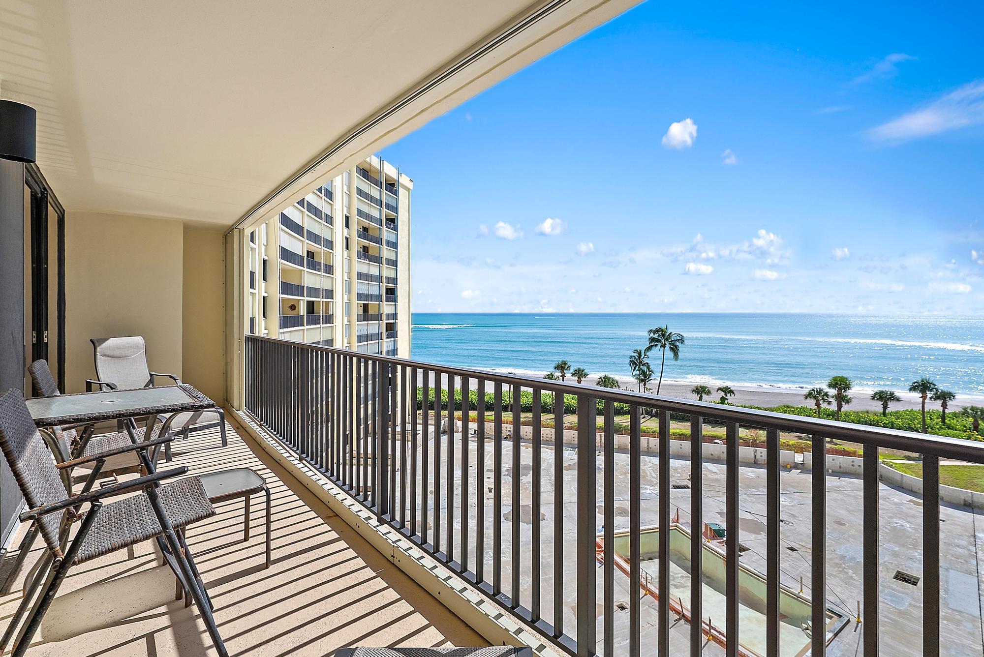 a view of a balcony with wooden floor and outdoor seating