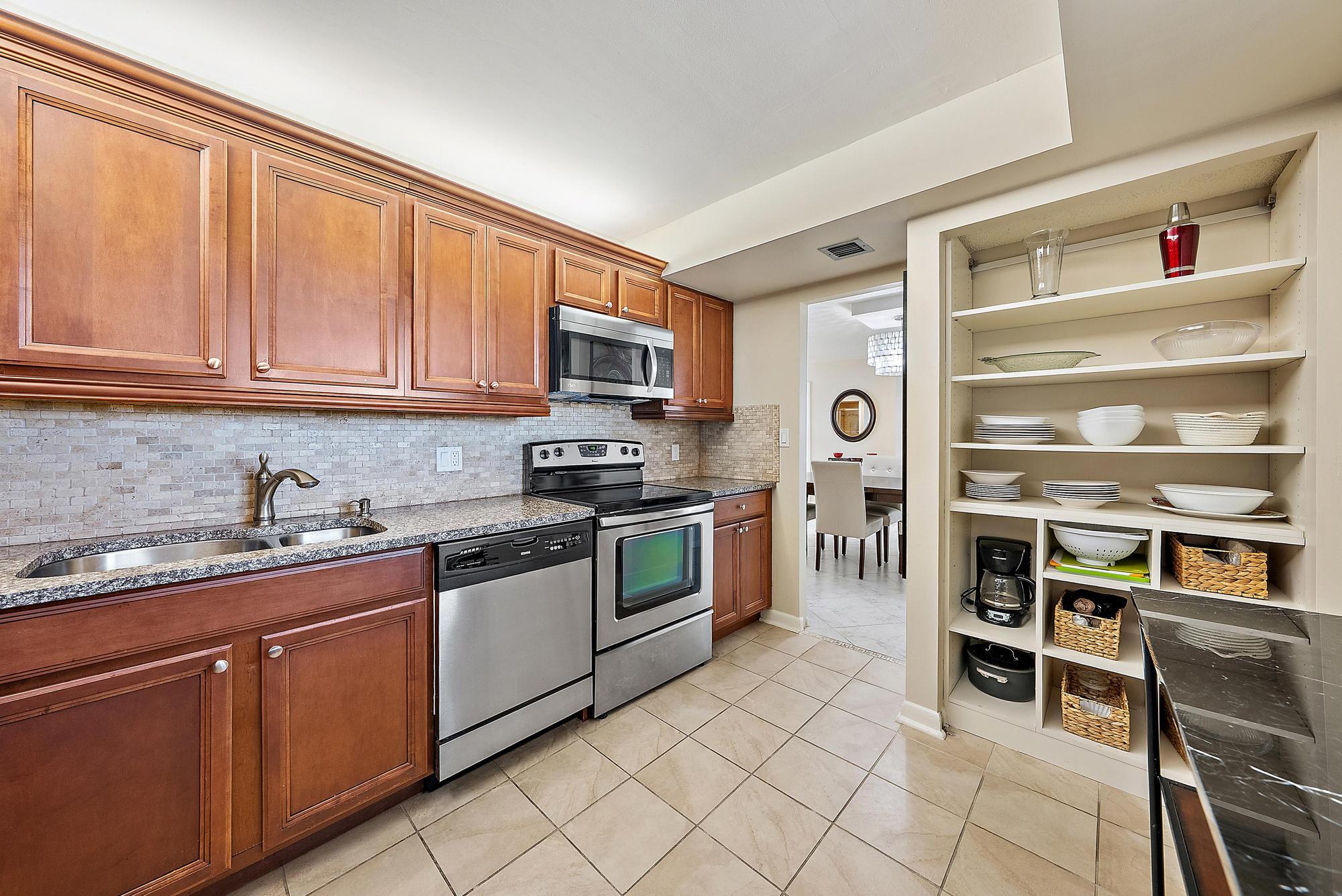400 Ocean Trail Way, Unit 707 Jupiter, FL 33477 - Photo 11 of 34 a kitchen with stainless steel appliances granite countertop a stove and cabinets