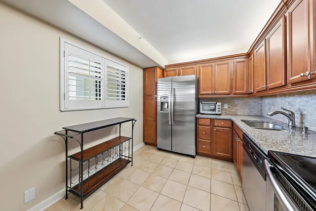 a kitchen with stainless steel appliances granite countertop a stove top oven a sink and dishwasher