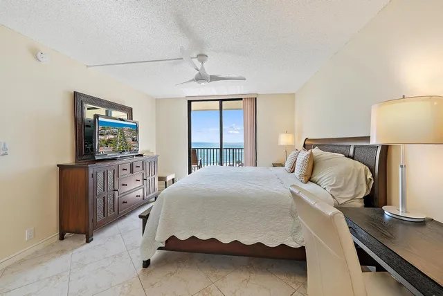 a bedroom with a bed and a flat tv screen on dresser