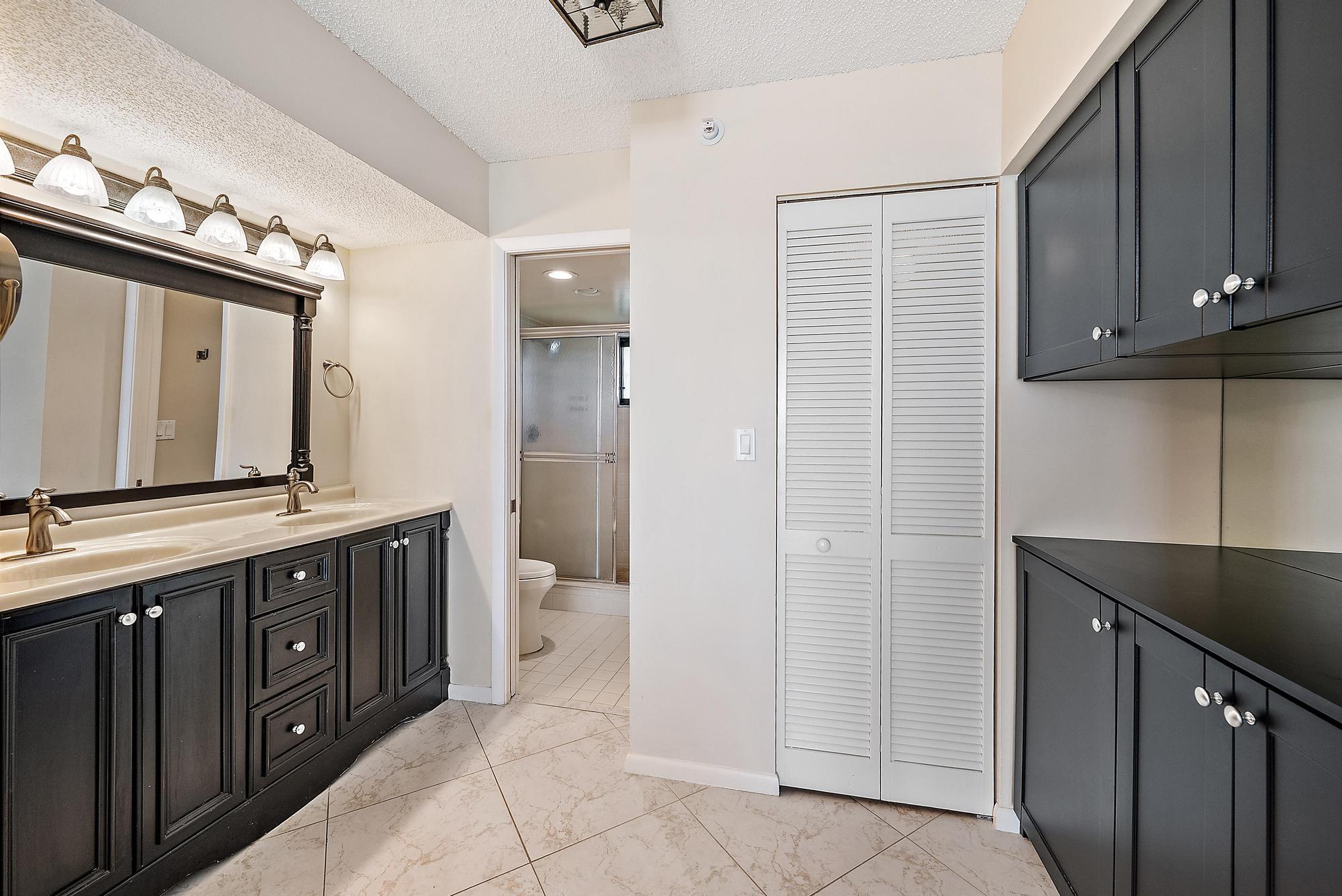 400 Ocean Trail Way, Unit 707 Jupiter, FL 33477 - Photo 14 of 34 a spacious bathroom with a double vanity sink a mirror and a shower