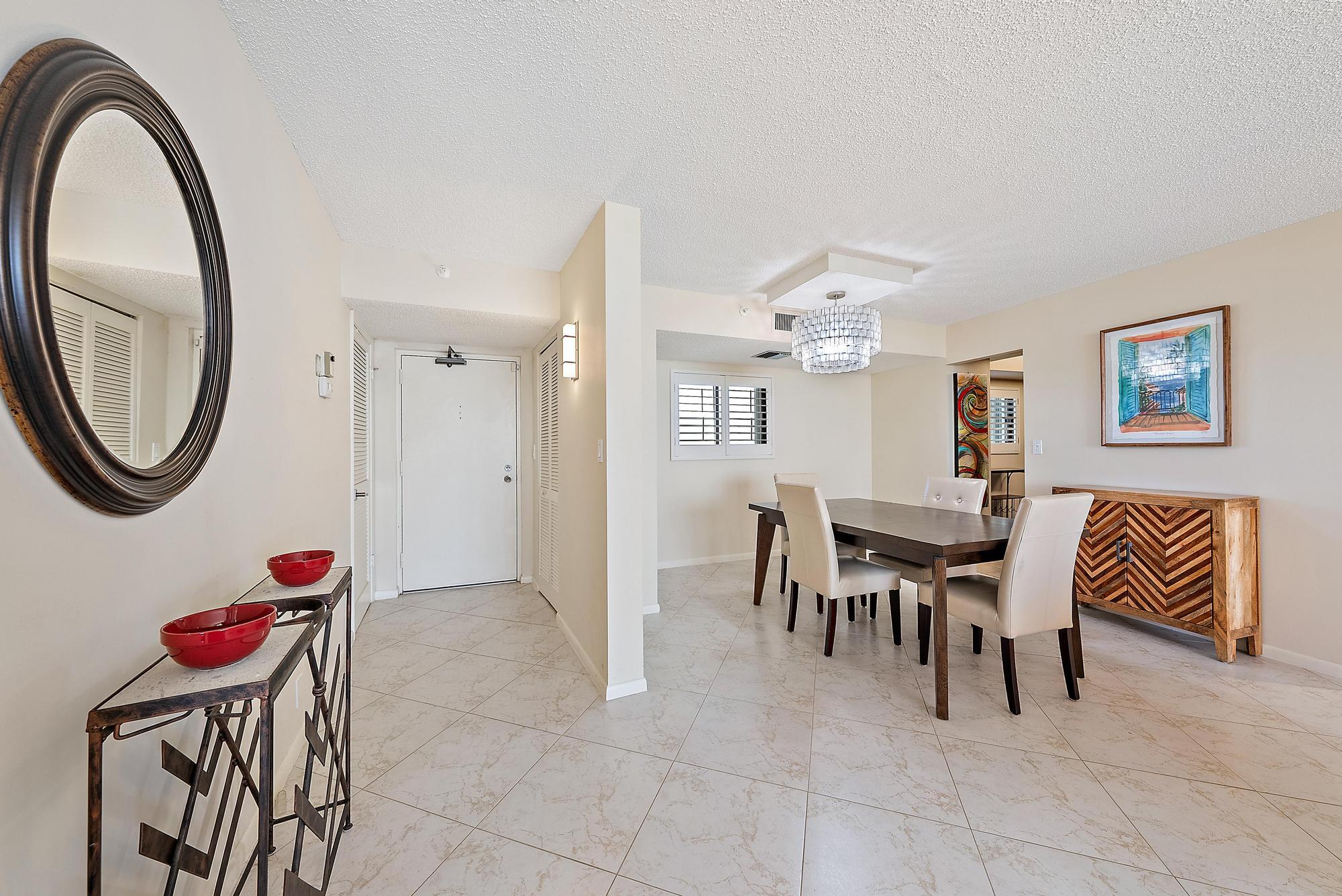 400 Ocean Trail Way, Unit 707 Jupiter, FL 33477 - Photo 2 of 34 a dining room with furniture and a mirror