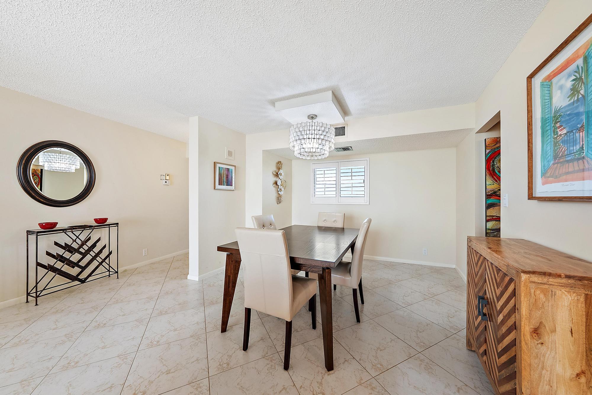 400 Ocean Trail Way, Unit 707 Jupiter, FL 33477 - Photo 3 of 34 a view of a dining room with furniture and a chandelier