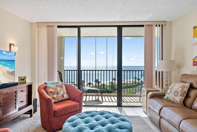 a living room with furniture and a floor to ceiling window