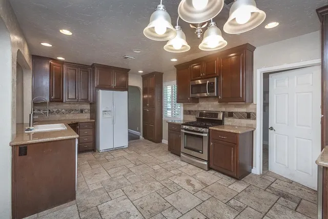 a view of a kitchen with a sink and a refrigerator