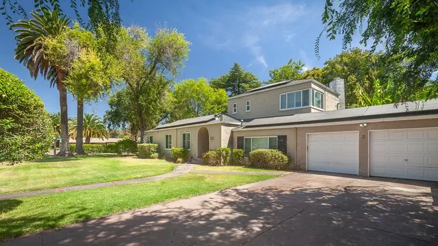 a front view of a house with yard and green space