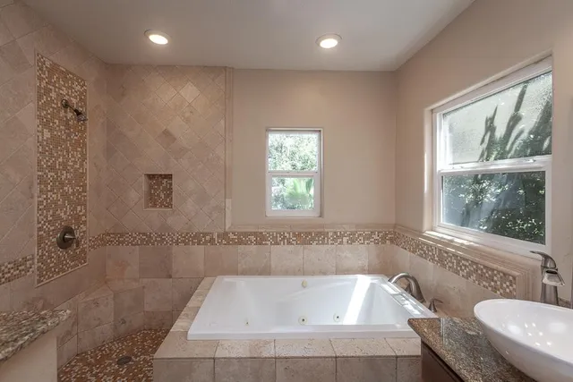an empty room with wooden floor a ceiling fan and windows