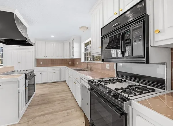 a large kitchen with stainless steel appliances granite countertop a stove and a sink