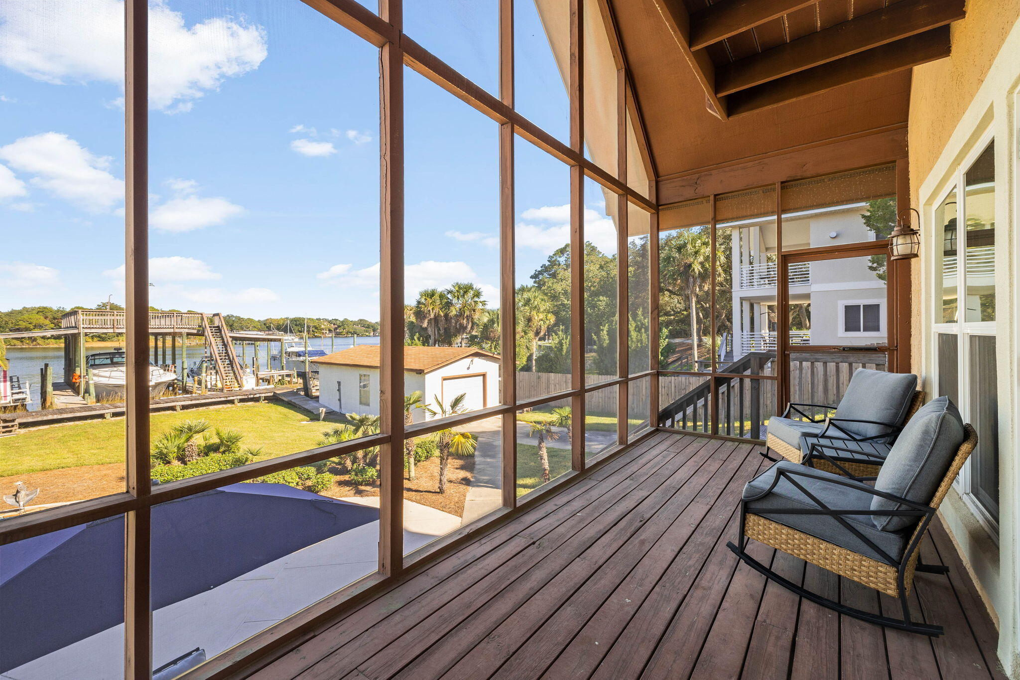 710 Beach Drive Destin, FL 32541 - Photo 22 of 64 a view of a balcony with chairs and wooden floor
