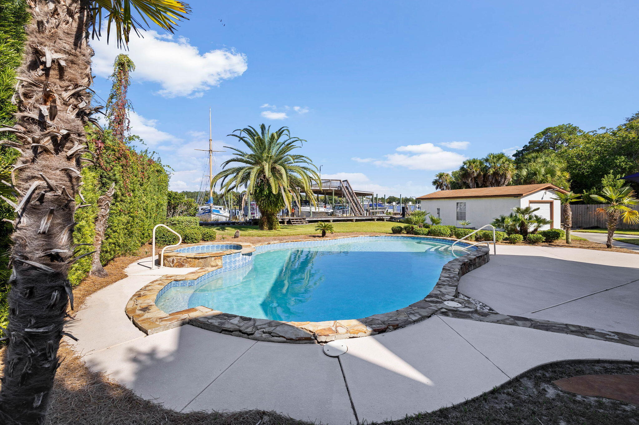 710 Beach Drive Destin, FL 32541 - Photo 47 of 64 a view of a swimming pool with lawn chairs under an umbrella
