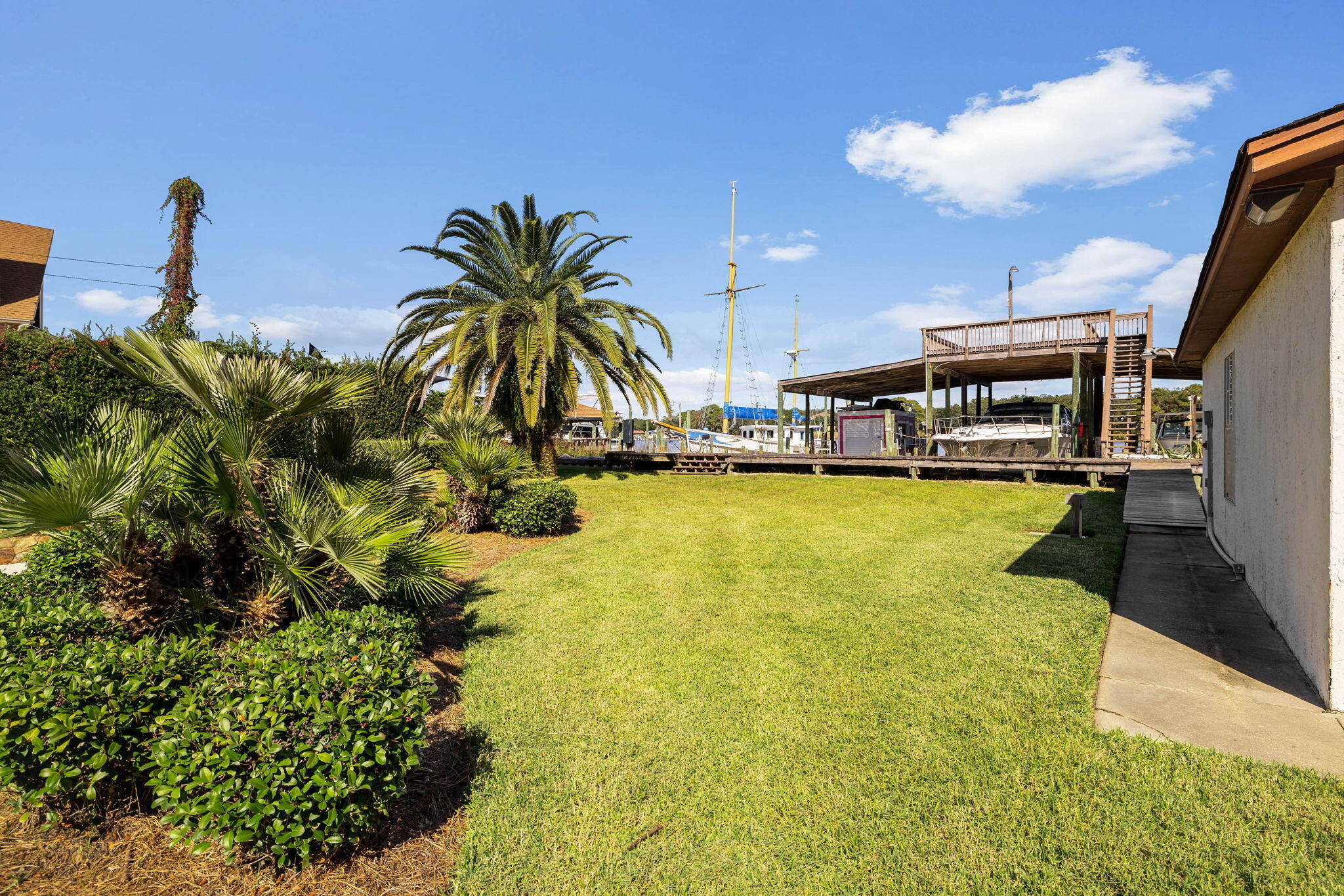710 Beach Drive Destin, FL 32541 - Photo 50 of 64 a view of a swimming pool with a lawn chairs and potted plants