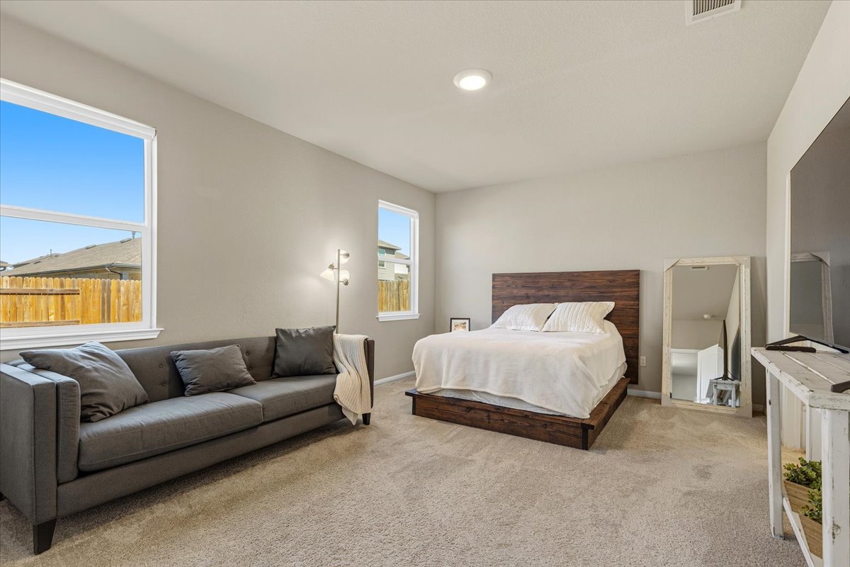 112 Rainmaker Cove Bastrop, TX 78602 - Photo 15 of 34 Bedroom featuring light carpet and baseboards