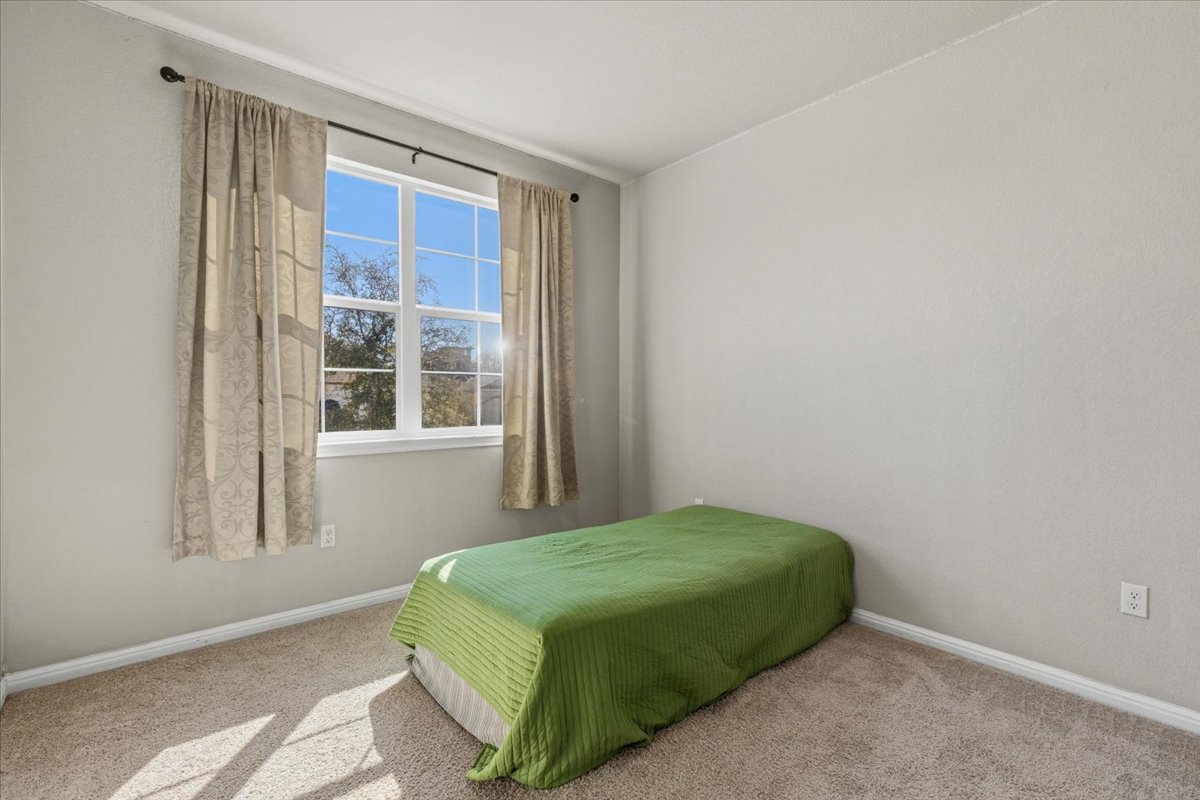112 Rainmaker Cove Bastrop, TX 78602 - Photo 23 of 34 Bedroom featuring light colored carpet and baseboards