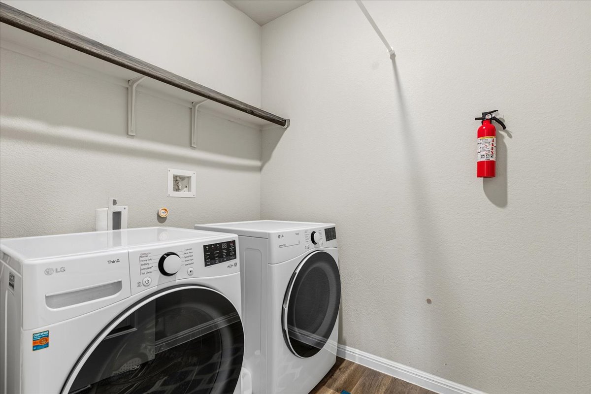 112 Rainmaker Cove Bastrop, TX 78602 - Photo 24 of 34 Laundry area with dark wood finished floors and separate washer and dryer