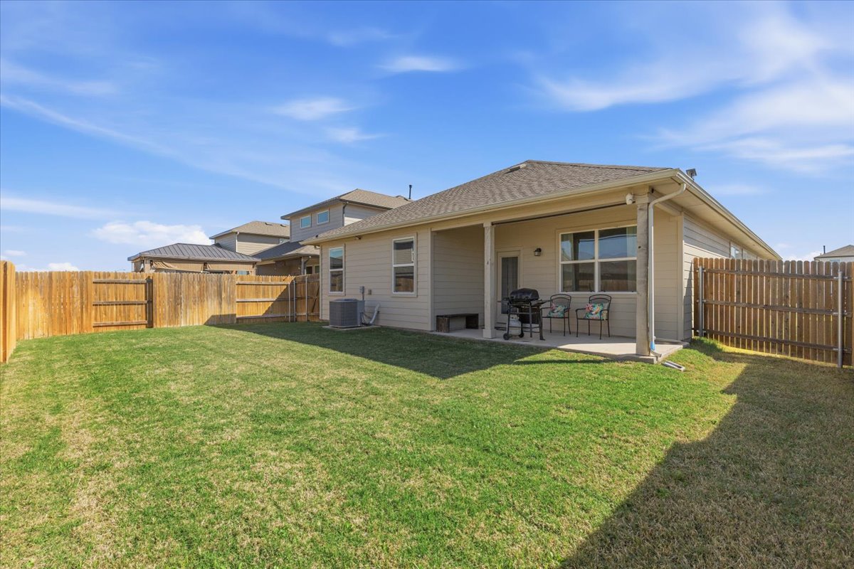 112 Rainmaker Cove Bastrop, TX 78602 - Photo 5 of 34 Rear view of house with a patio and a fenced backyard