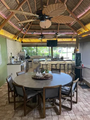 a dining room with stainless steel appliances a table and chairs