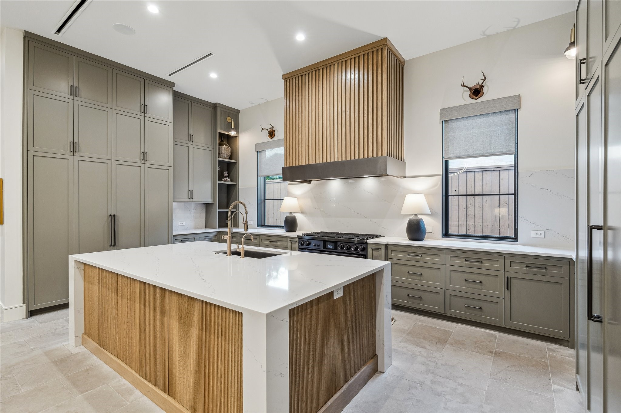 3807 Westerman Street Houston, TX 77005 - Photo 16 of 50 Soft-closing cabinets with matte black hardware create a sleek and functional space, highlighted by a designer chandelier. Linear air vents maintain a clean, modern aesthetic, while