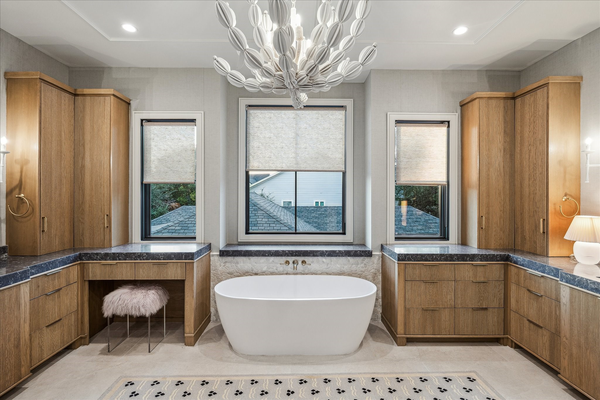 3807 Westerman Street Houston, TX 77005 - Photo 30 of 50 The primary bath exudes luxury with custom grass cloth wall coverings, recessed LED lighting, and a striking custom accent ceiling design. A soaking tub offers a serene retreat, while the walk-in shower features a seamless glass door, built-in niche, and designer finishes. Windows with western exposure fill the space with soft, natural light, creating a tranquil spa-like atmosphere.