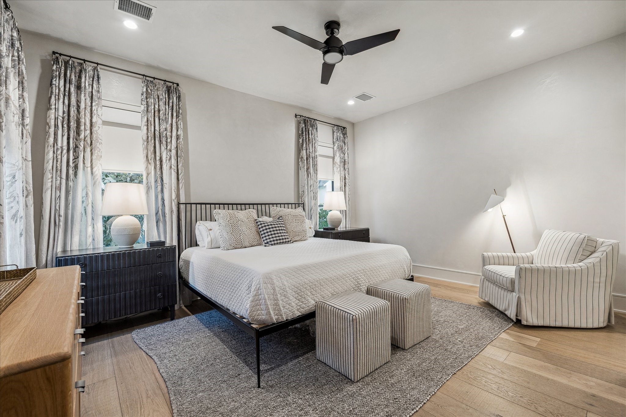 3807 Westerman Street Houston, TX 77005 - Photo 42 of 50 Guest Bedroom 5 features 10’ ceilings with neutral plaster walls and ceiling, recessed LED lighting, and a ceiling fan with light kit. A walk-in closet offers custom shelving, drawers, and hanging rods for ample storage. This bedroom shares a well-appointed bathroom with Guest Bedroom 4, combining comfort and convenience.
