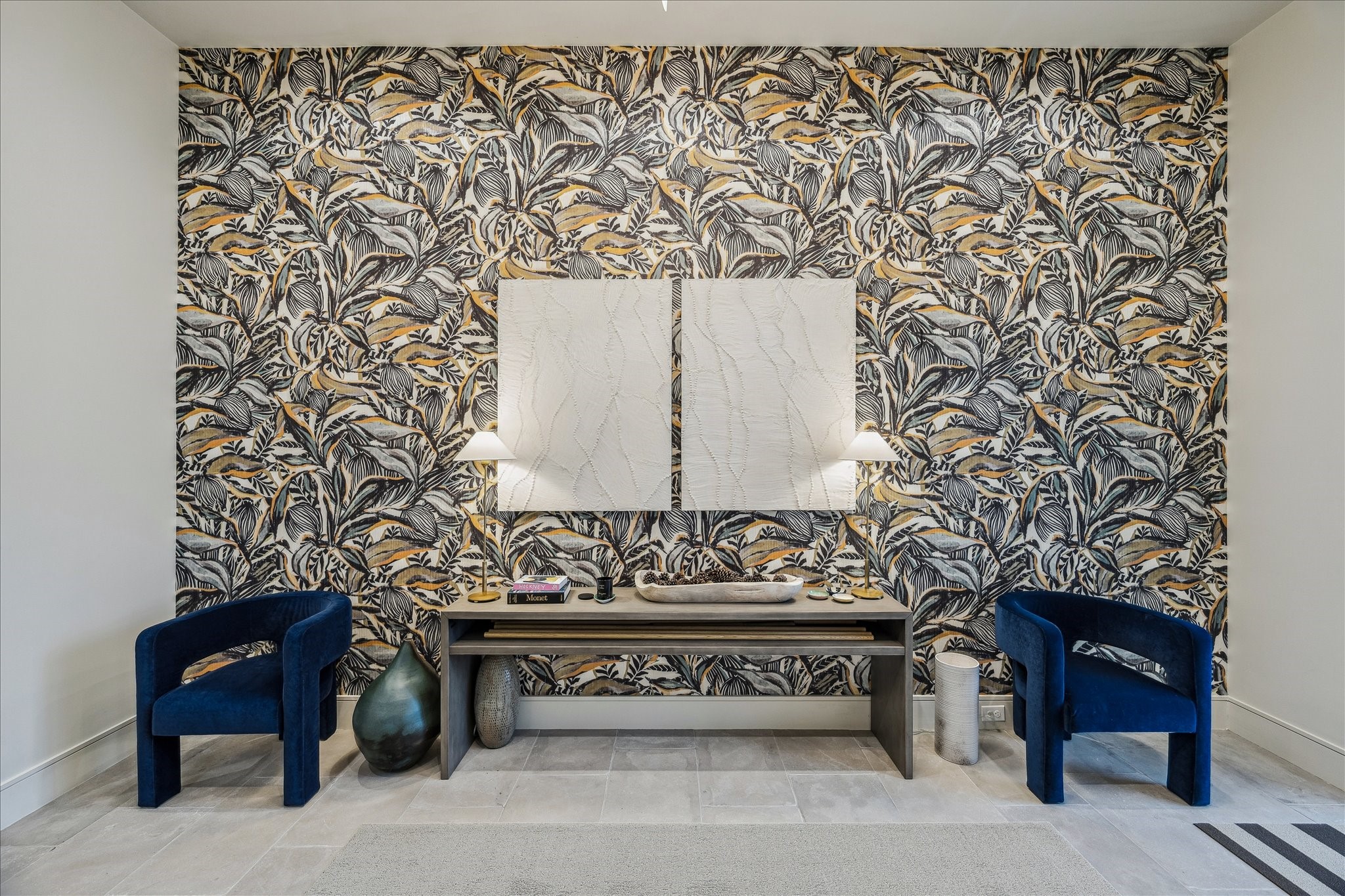 3807 Westerman Street Houston, TX 77005 - Photo 5 of 50 The feature wall of the foyer showcases designer print wallpaper complemented by neutral wall tones and elegant stone flooring. Recessed LED lighting, linear air vents, and a statement chandelier highlight the space’s refined design. This grand entry provides seamless access to the study and the sweeping staircase beyond.