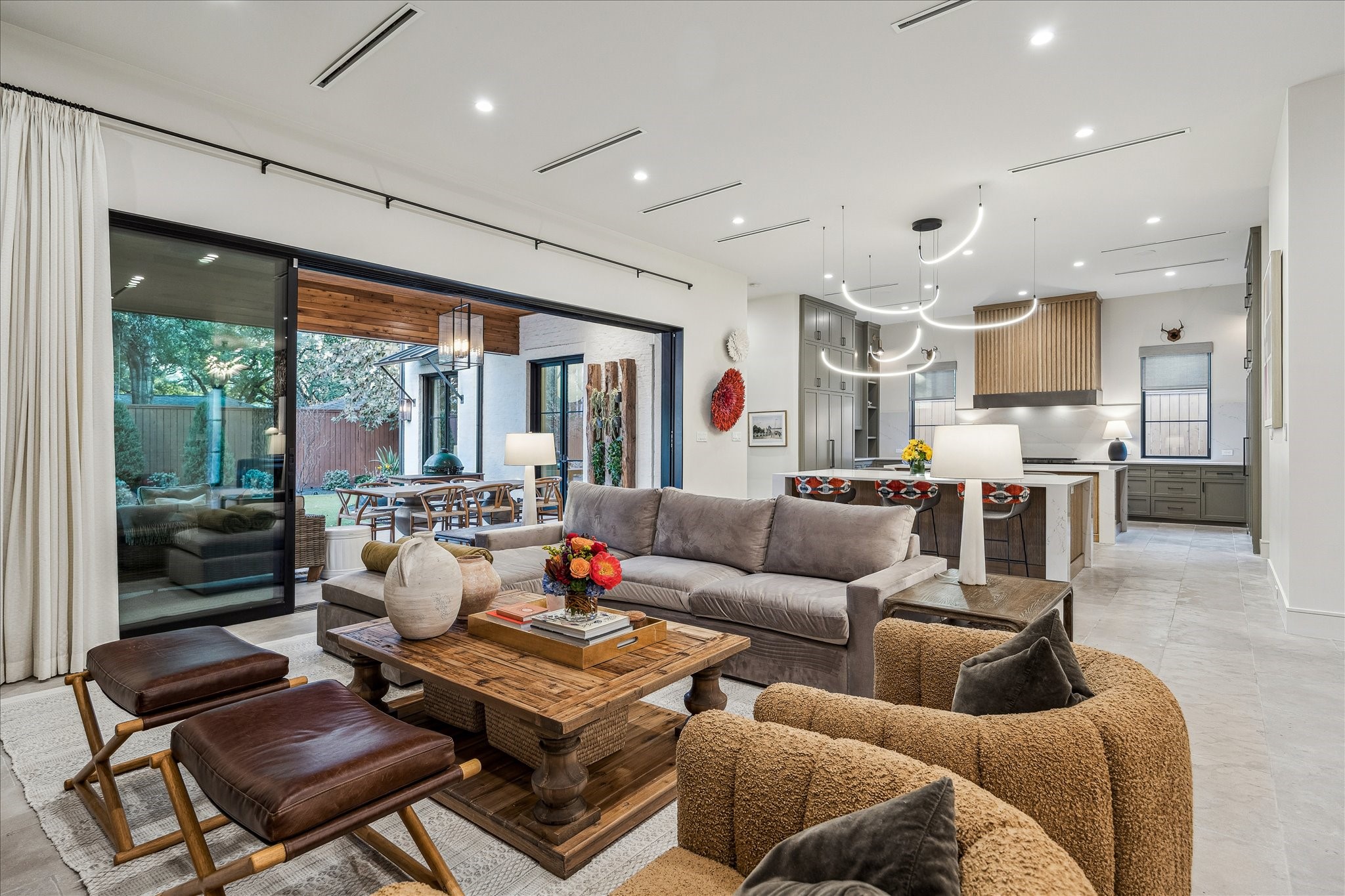 3807 Westerman Street Houston, TX 77005 - Photo 10 of 50 The family room seamlessly connects to the expansive covered patio, creating an effortless extension of your living space. Open to the designer kitchen, this inviting area features neutral designer wall paint, linear air vents, and recessed can lighting for a polished, contemporary feel.