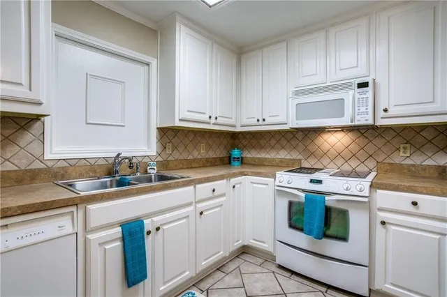 a kitchen with granite countertop white cabinets and white appliances