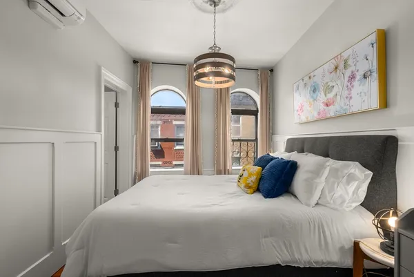 a bedroom with a bed and a painting on the wall