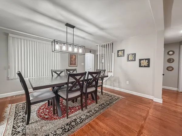 a dining room with furniture a rug and wooden floor