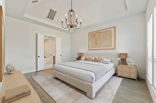 a bedroom with a large bed and a chandelier