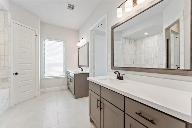 a bathroom with a double vanity sink a mirror and a bathtub