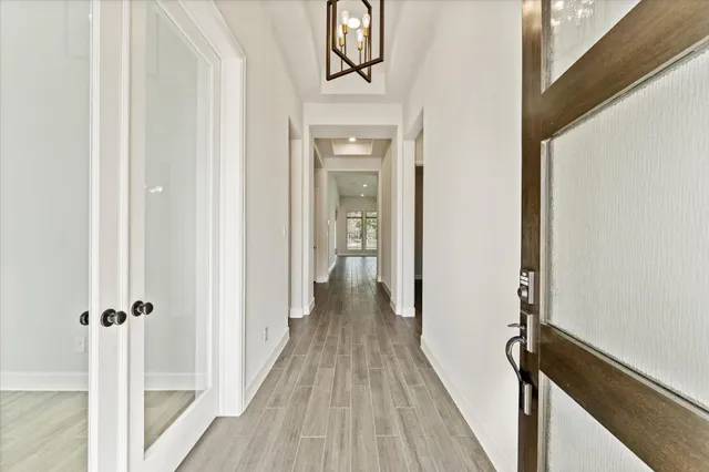 a view of a hallway with wooden floor and staircase