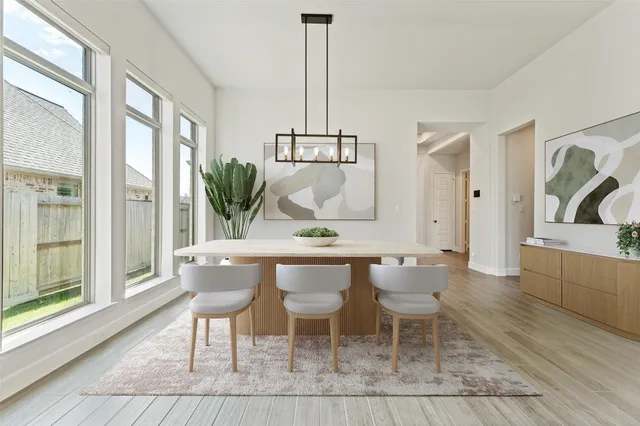 a dining room with furniture a chandelier and wooden floor