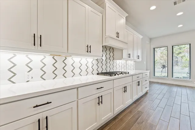 a kitchen with granite countertop white cabinets and white appliances