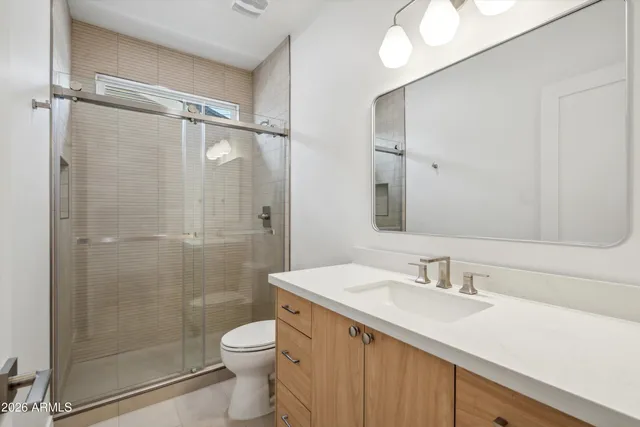 a bathroom with a double vanity sink mirror and toilet