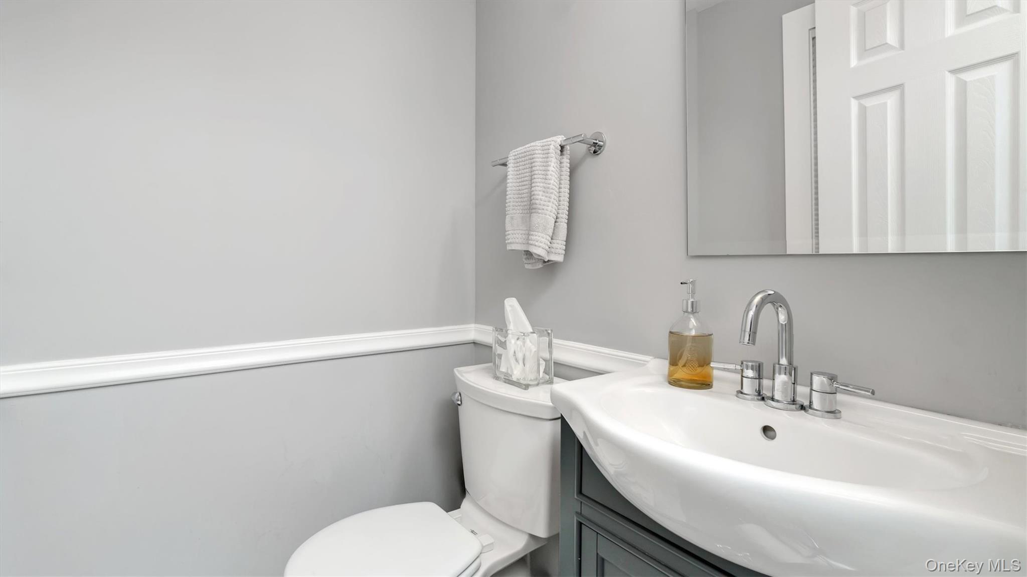 19 Barstow Road, Unit G Great Neck, NY 11021 - Photo 14 of 36 a bathroom with a sink a toilet and mirror