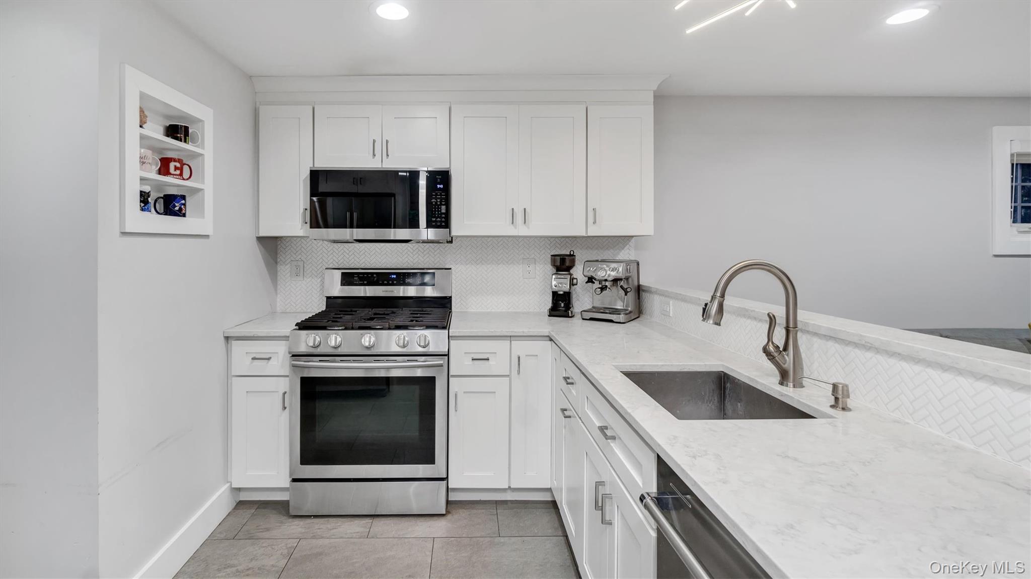 19 Barstow Road, Unit G Great Neck, NY 11021 - Photo 17 of 36 a kitchen with a sink stove and microwave