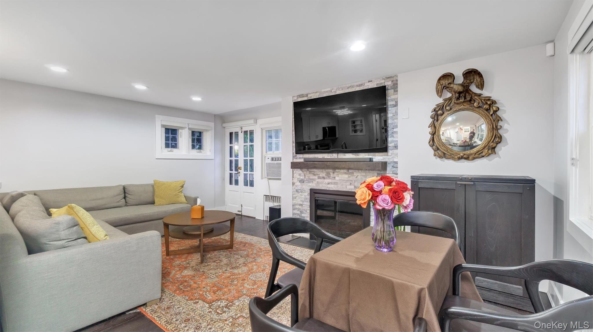 19 Barstow Road, Unit G Great Neck, NY 11021 - Photo 19 of 36 a living room with furniture a flat screen tv and a fireplace