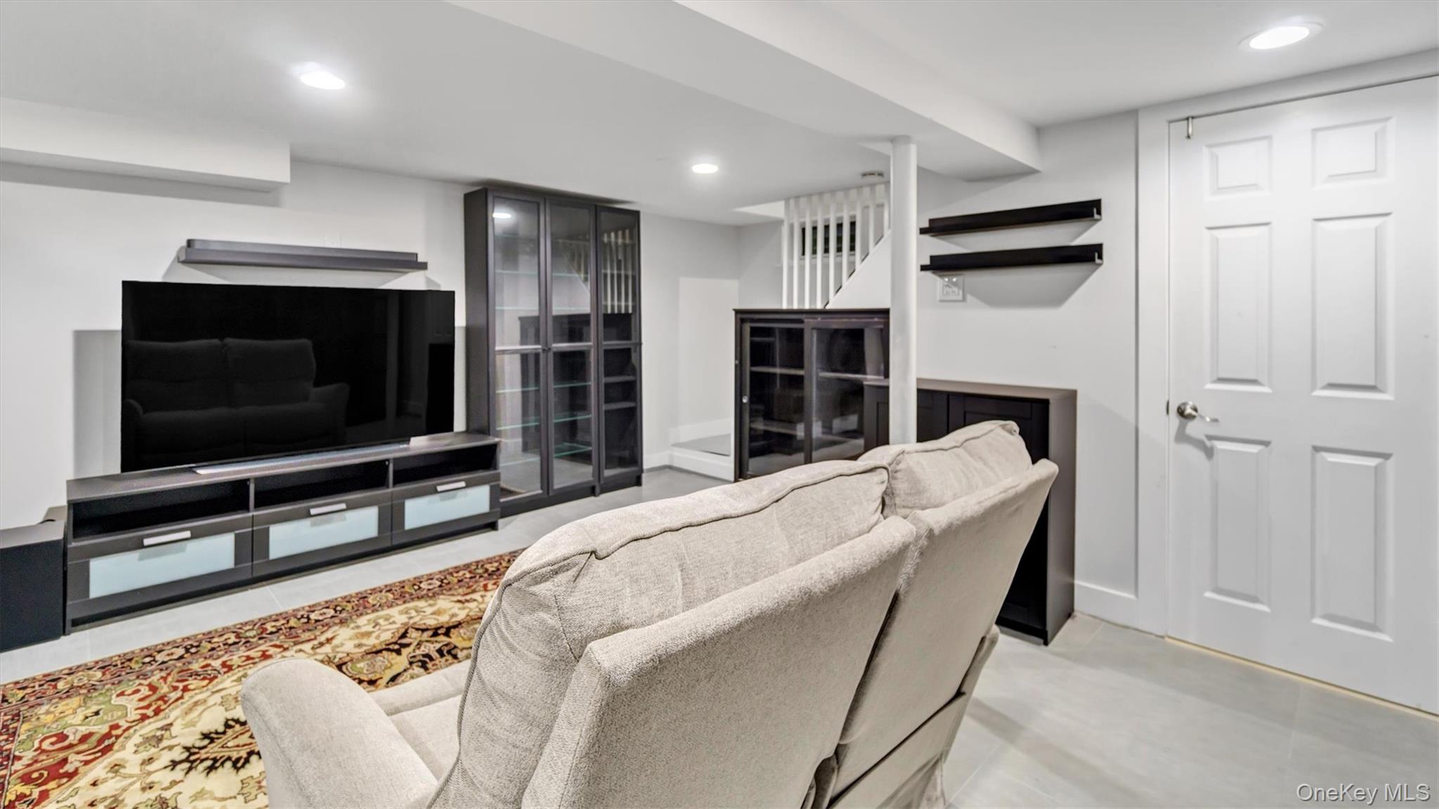 19 Barstow Road, Unit G Great Neck, NY 11021 - Photo 28 of 36 a living room with furniture and a flat screen tv