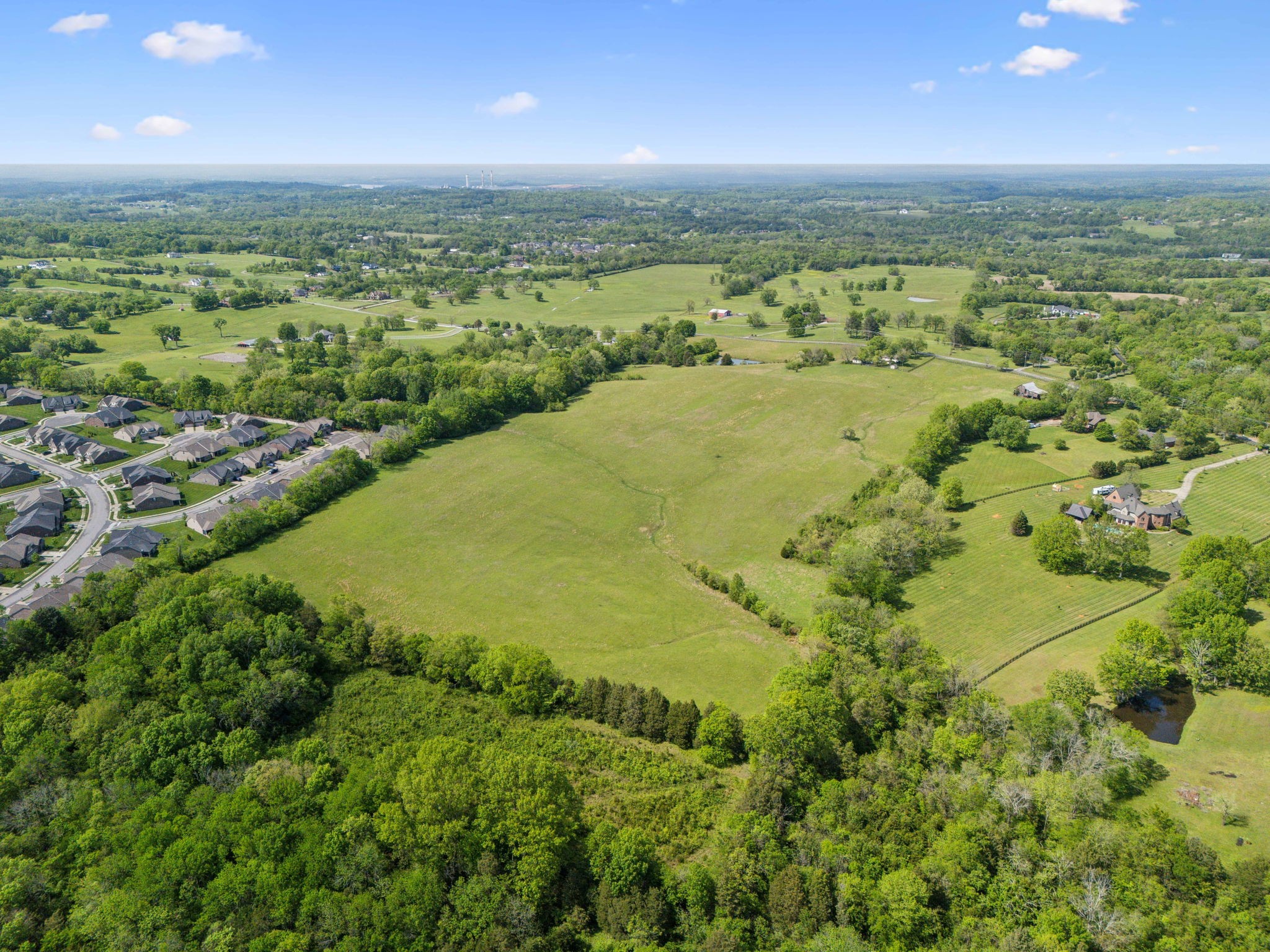 an aerial view of residential houses with outdoor space and trees