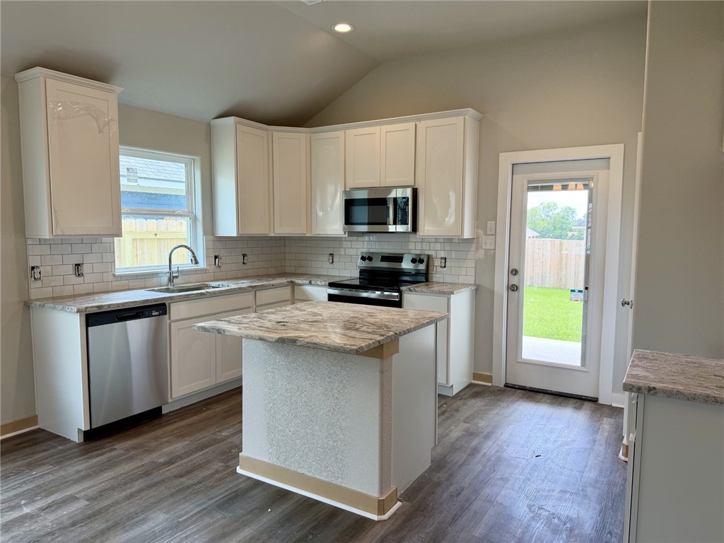 2791 Messenger Way Bryan, TX 77803 - Photo 2 of 15 a kitchen with granite countertop a stove a sink and a microwave