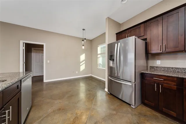 an empty room with a chandelier fan and windows