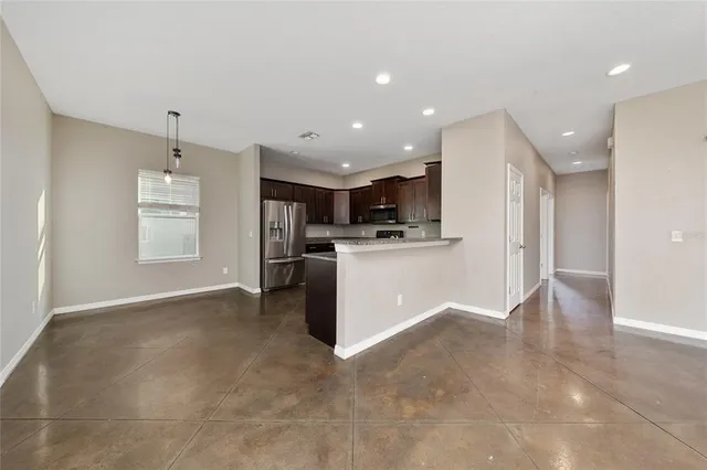 an empty room with a chandelier fan and closet area
