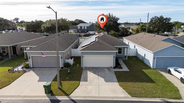 an aerial view of residential houses with outdoor space and lake view