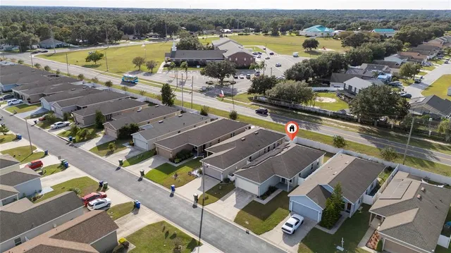 an aerial view of residential houses with outdoor space and parking
