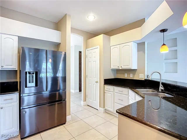 a kitchen with granite countertop a refrigerator and a sink