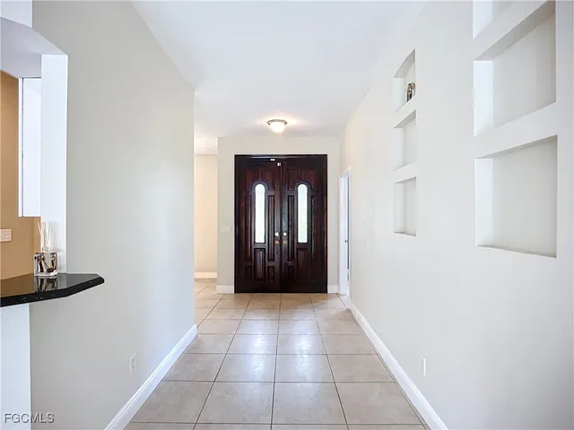 a view of a hallway with wooden floor and a bathroom