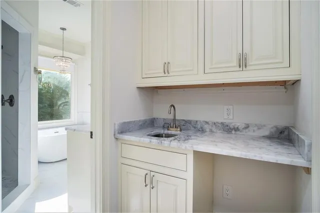 a kitchen with stainless steel appliances granite countertop a sink and a white cabinets with wooden floor