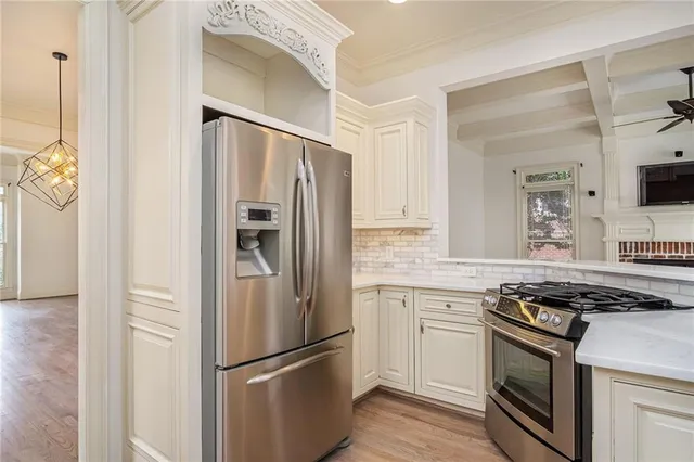 a kitchen with stainless steel appliances granite countertop a refrigerator and a stove top oven